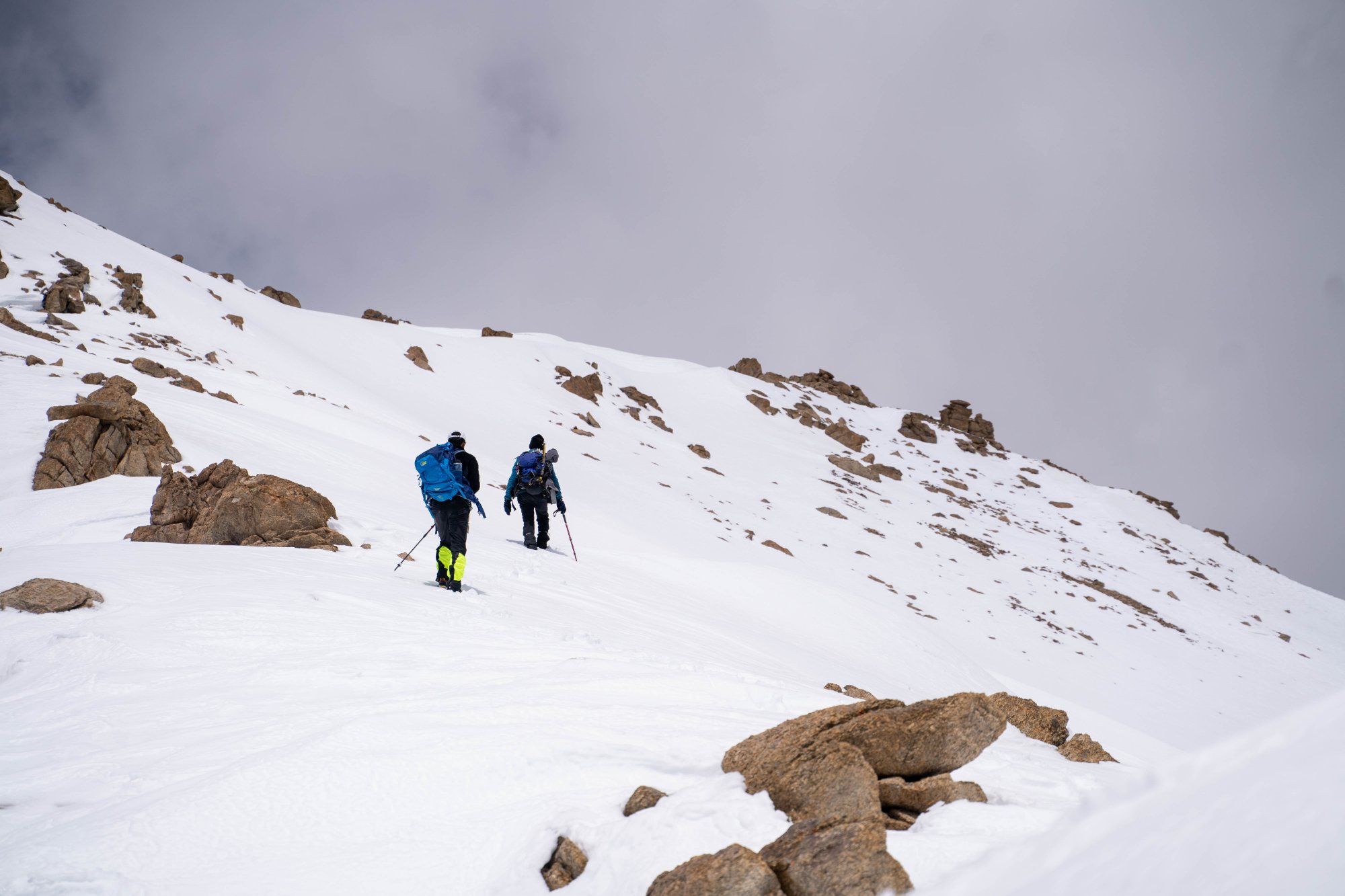 Two mountaineers ascending a steep snow slope in the Karakoram